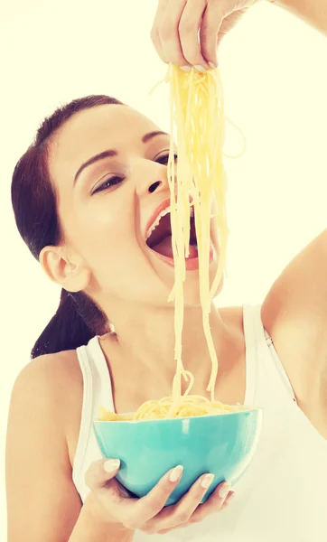 Junge schöne Frau isst rohe Pasta. — Stockfoto