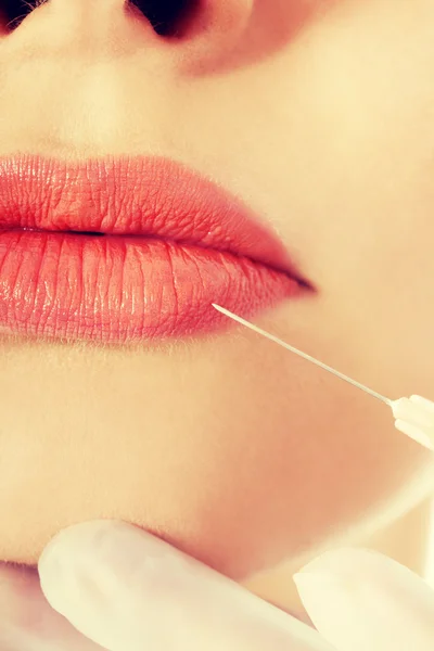 Young beautiful woman doing injection into mouth. — Stock Photo, Image