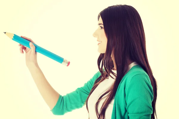 Young woman writing on copy space with pencil. — Stock Photo, Image