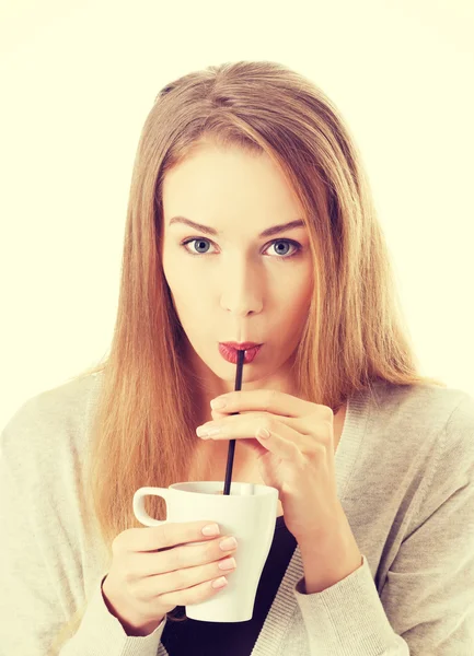 La mujer bebe de una taza con una pajita . — Foto de Stock