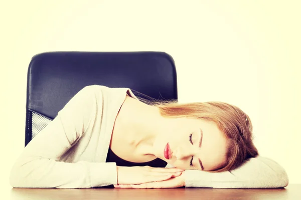 Jovem mulher casual está dormindo em uma mesa . — Fotografia de Stock