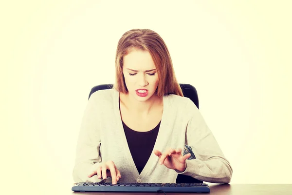 Schöne Frau, die vor Wut auf der Tastatur schreibt. — Stockfoto