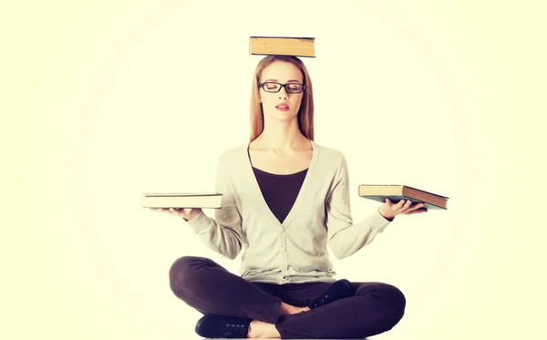 Bella donna casual seduta con libri sulla testa — Foto Stock