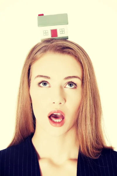 Shocked business woman with house on head. — Stock Photo, Image