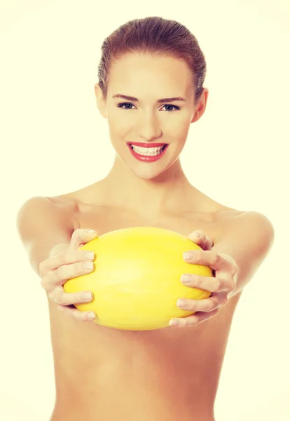 Hermosa mujer sostiene melón fresco amarillo . — Foto de Stock