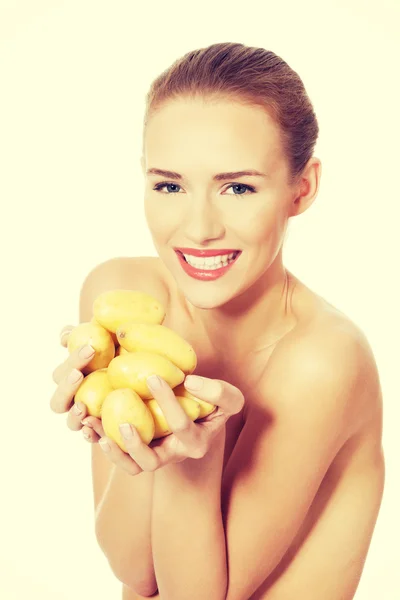 Beautiful woman holding raw potatoes in hands. — Stock Photo, Image