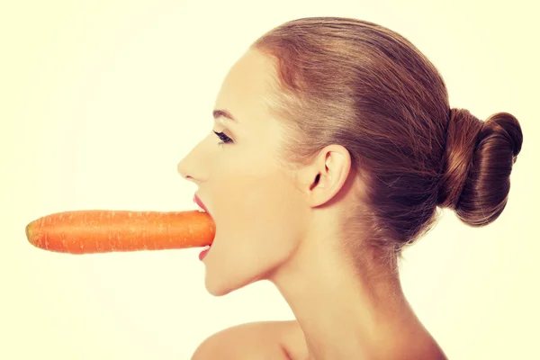 Profile of caucasian woman eating carrot. — Stock Photo, Image