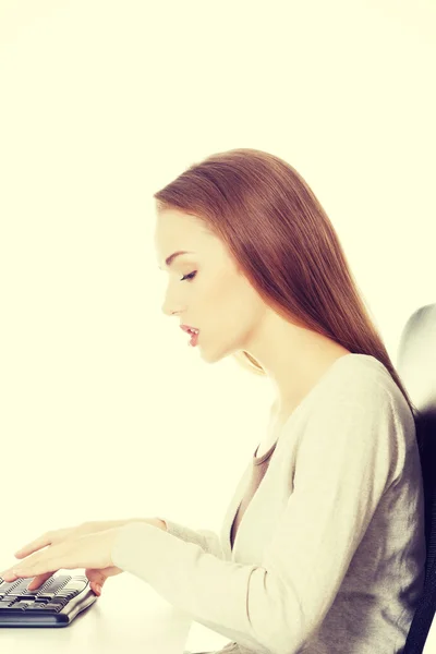 Beautiful woman student is writing on keyboard. Royalty Free Stock Photos