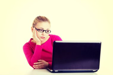 laptop önünde oturan sıkılmış, hüzünlü kadın.