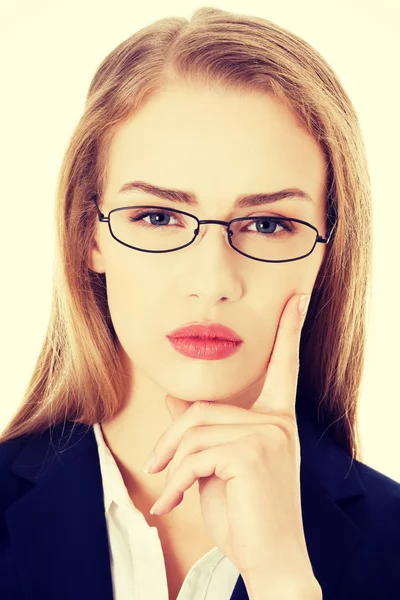 Mujer de negocios en gafas con el dedo en la mejilla . —  Fotos de Stock