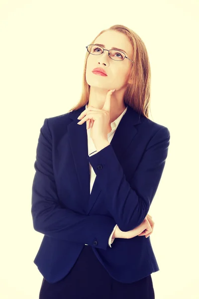 Mujer de negocios en gafas con el dedo en la mejilla . —  Fotos de Stock