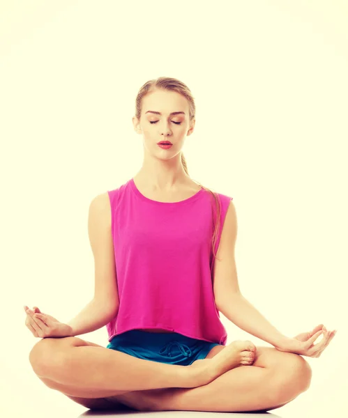 Beautiful young woman is exercising, doing yoga. — Stock Photo, Image