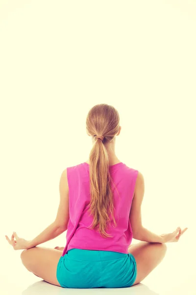 Beautiful young woman is exercising, doing yoga. — Stock Photo, Image