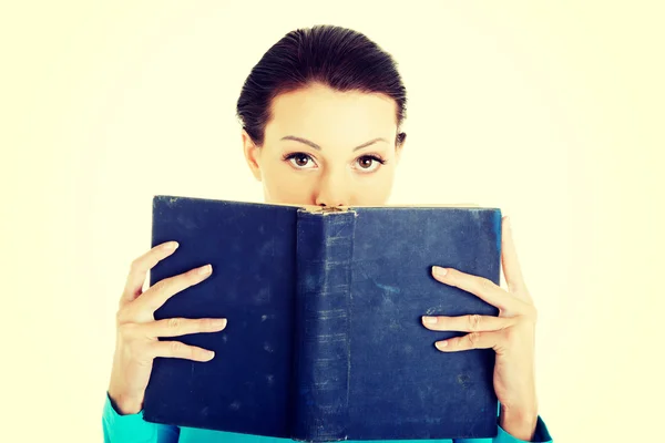 Student vrouw met een boek op haar gezicht. — Stockfoto