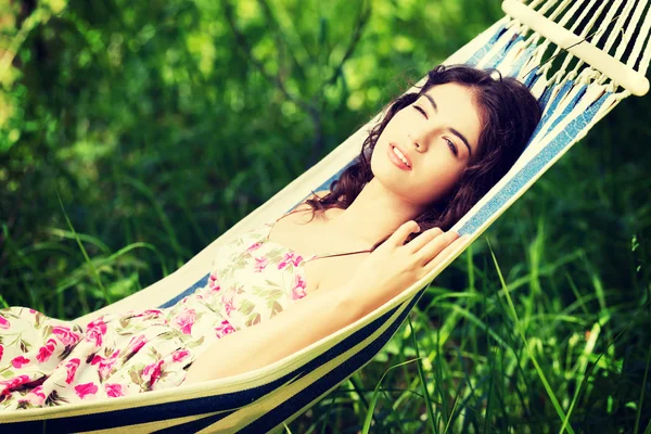 Young woman in dress relaxing in a hammock. — Stock Photo, Image