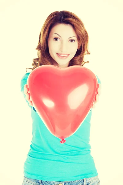 Attractive woman giving a baloon heart. — Stock Photo, Image