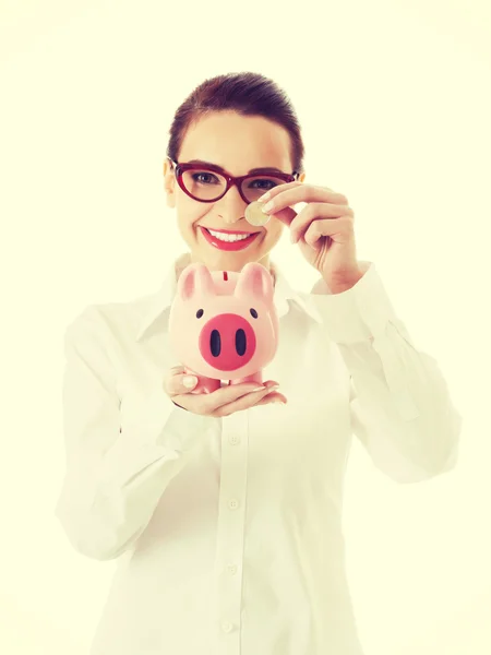 Geschäftsfrau mit Münze und Sparschwein. — Stockfoto