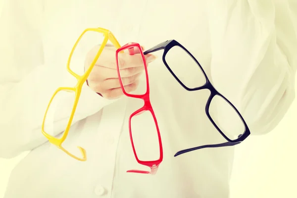 Femme tenant trois paires de lunettes différentes — Photo