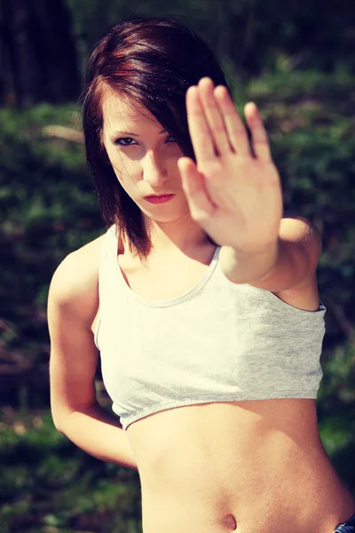 Jeune femme en haut blanc montrant stop signe . Photo De Stock