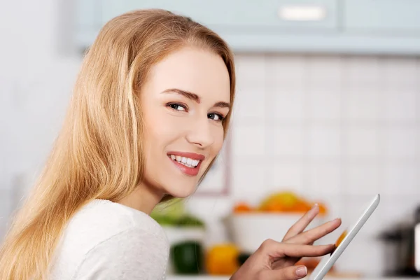 Mujer joven usando una tableta en casa — Foto de Stock