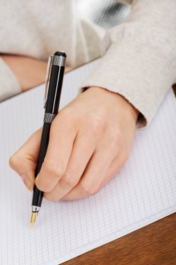 el ile bir defter kalem yazıyor.