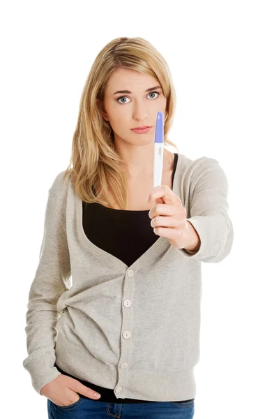 Sad young woman holding pregnancy test — Stock Photo, Image
