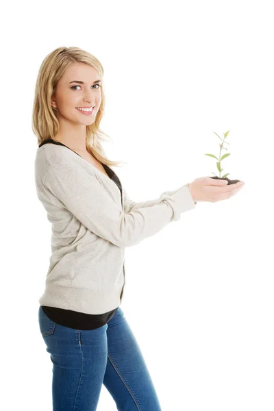 Женщина с растением и грязью в руке — стоковое фото