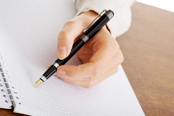 Hand schrijft met een pen in een notitieblok — Stockfoto