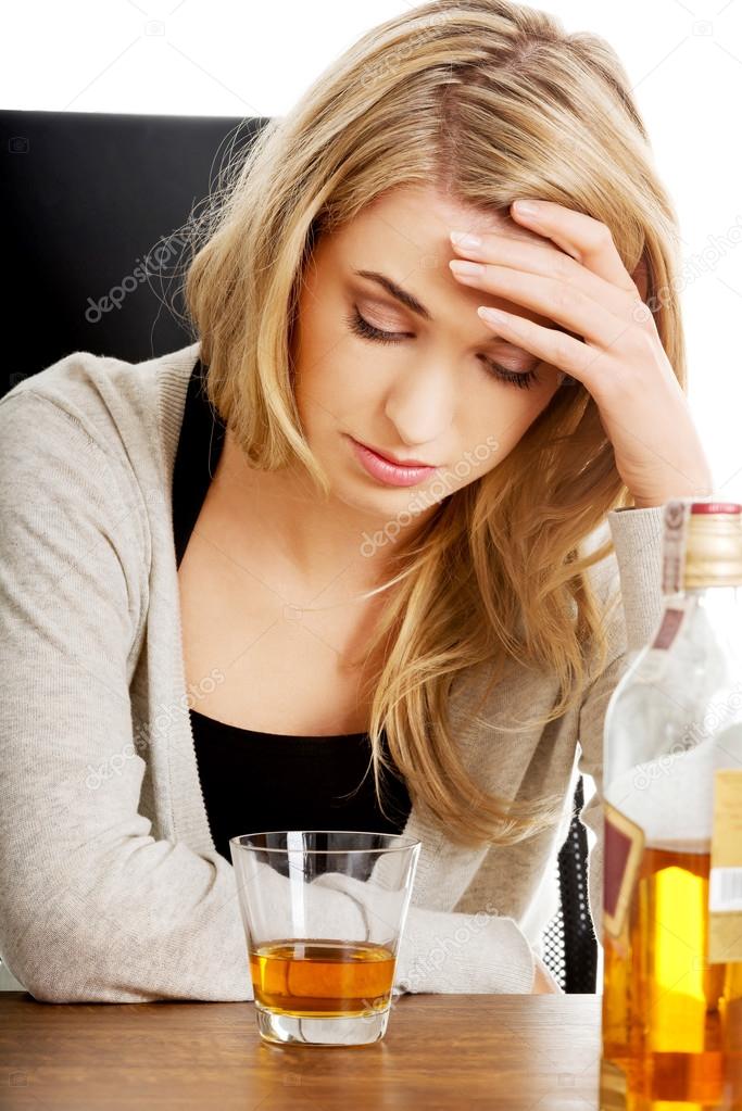Yound woman in depression, drinking alcohol
