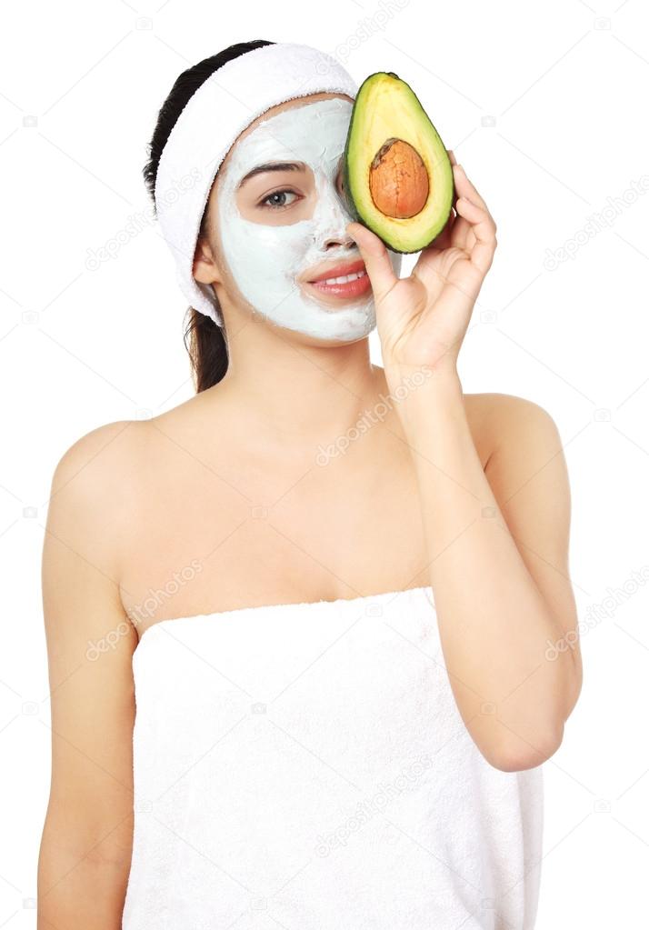 Beautiful spa woman in facial mask and avocado