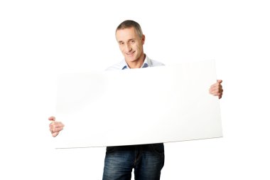 yakışıklı adam boş bir afiş tutarak