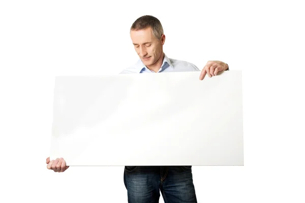 Handsome man holding an empty banner — Stock Photo, Image