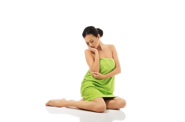 Bella donna seduta avvolta in asciugamano — Foto Stock