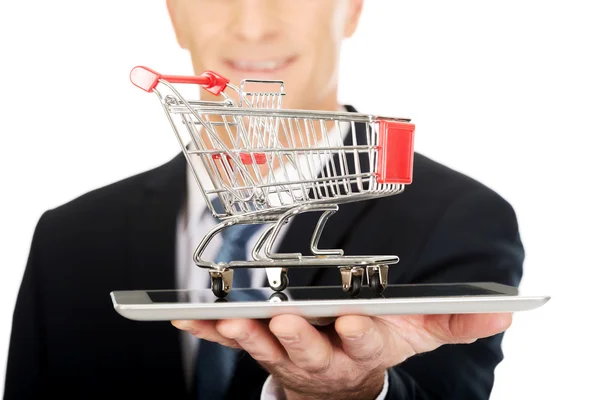 Man holding shopping cart on tablet — Stock Photo, Image