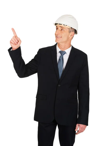 Mature engineer with hard hat pointing up — Stock Photo, Image