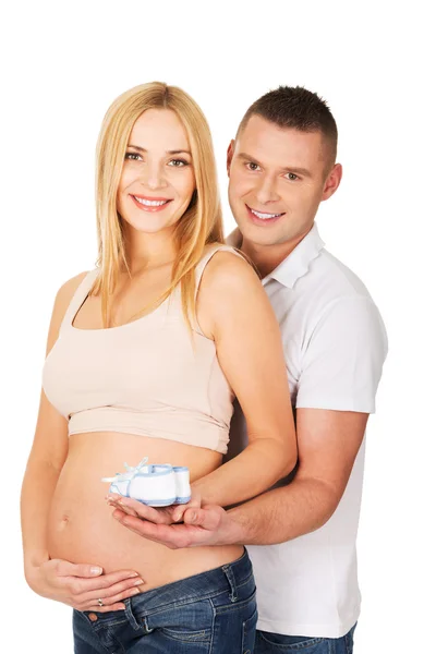Pregnant couple with small blue shoes — Stock Photo, Image
