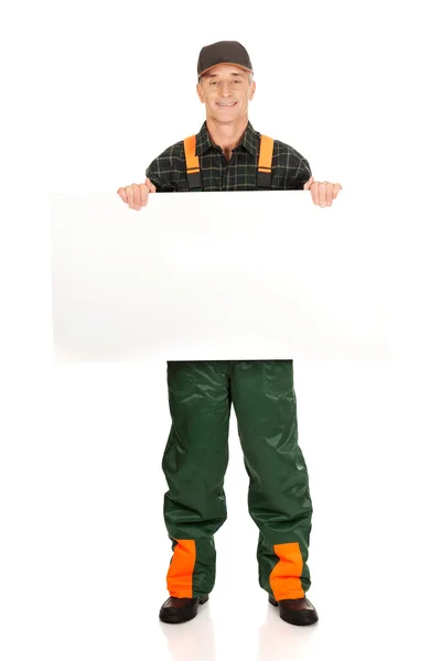 Gardener in uniform showing empty banner — Stock Photo, Image