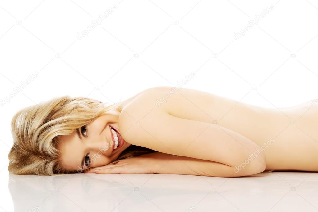 Nude woman lying on belly and looking up