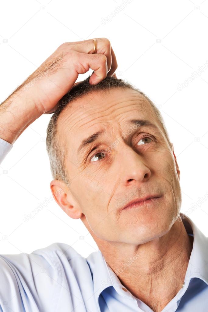 Confused man scratching his head