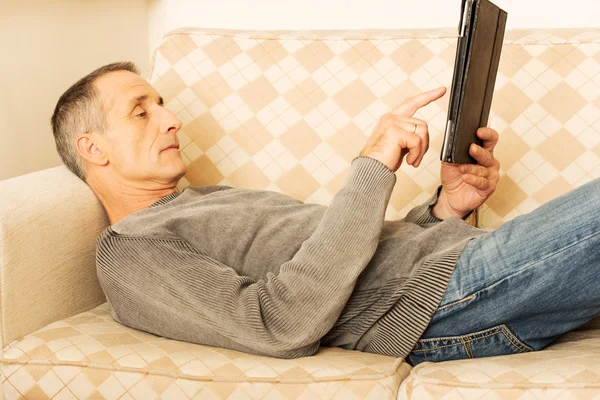 Volwassen man met behulp van digitale tablet thuis — Stockfoto