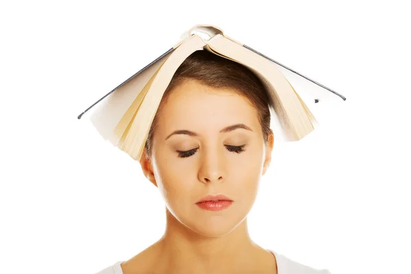 Kobieta gospodarstwa książki na głowie — Zdjęcie stockowe
