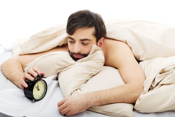Hombre agotado siendo despertado por un despertador. —  Fotos de Stock