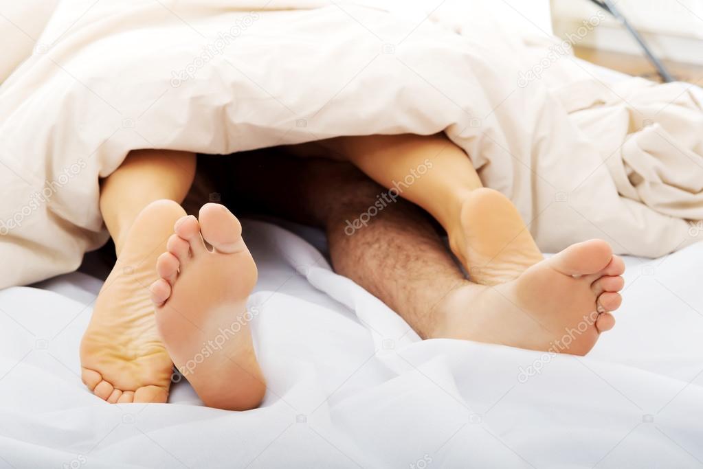 Couple's feet in bed.