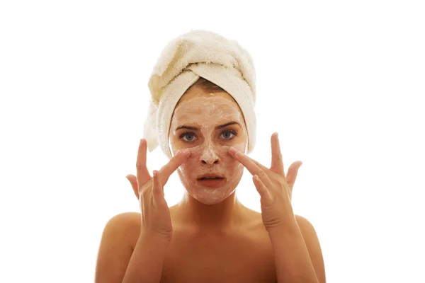 Mujer aplicando una crema en su cara — Foto de Stock