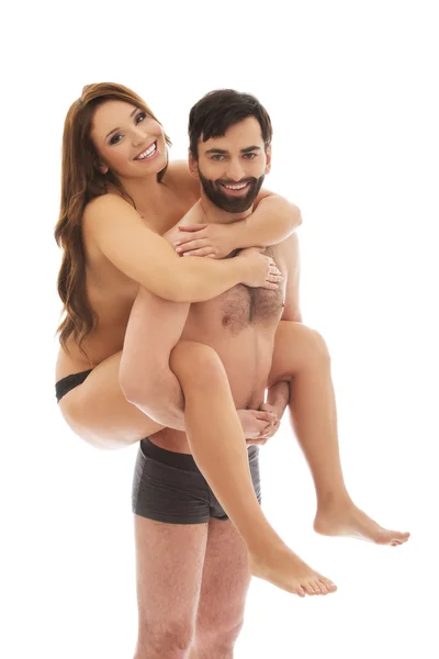 Man carrying girlfriend on his back. — Stock Photo, Image