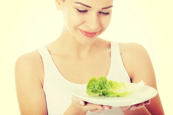 Mujer con lechuga en un plato . —  Fotos de Stock