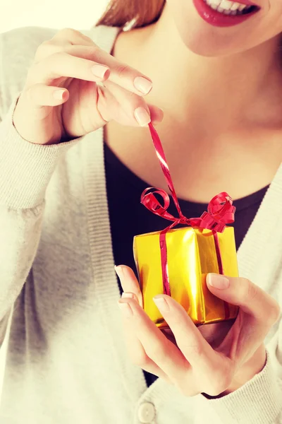 Güzel bir kadın küçük hediye unwrapping. — Stok fotoğraf