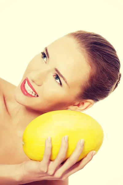 Beautiful woman holds yellow fresh melon. — Stock Photo, Image