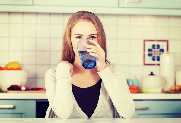 Schöne kaukasische Frau sitzt in der Küche — Stockfoto