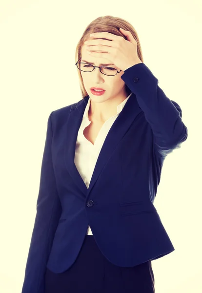 Beautiful business woman is touching her forehead. — Stock Photo, Image